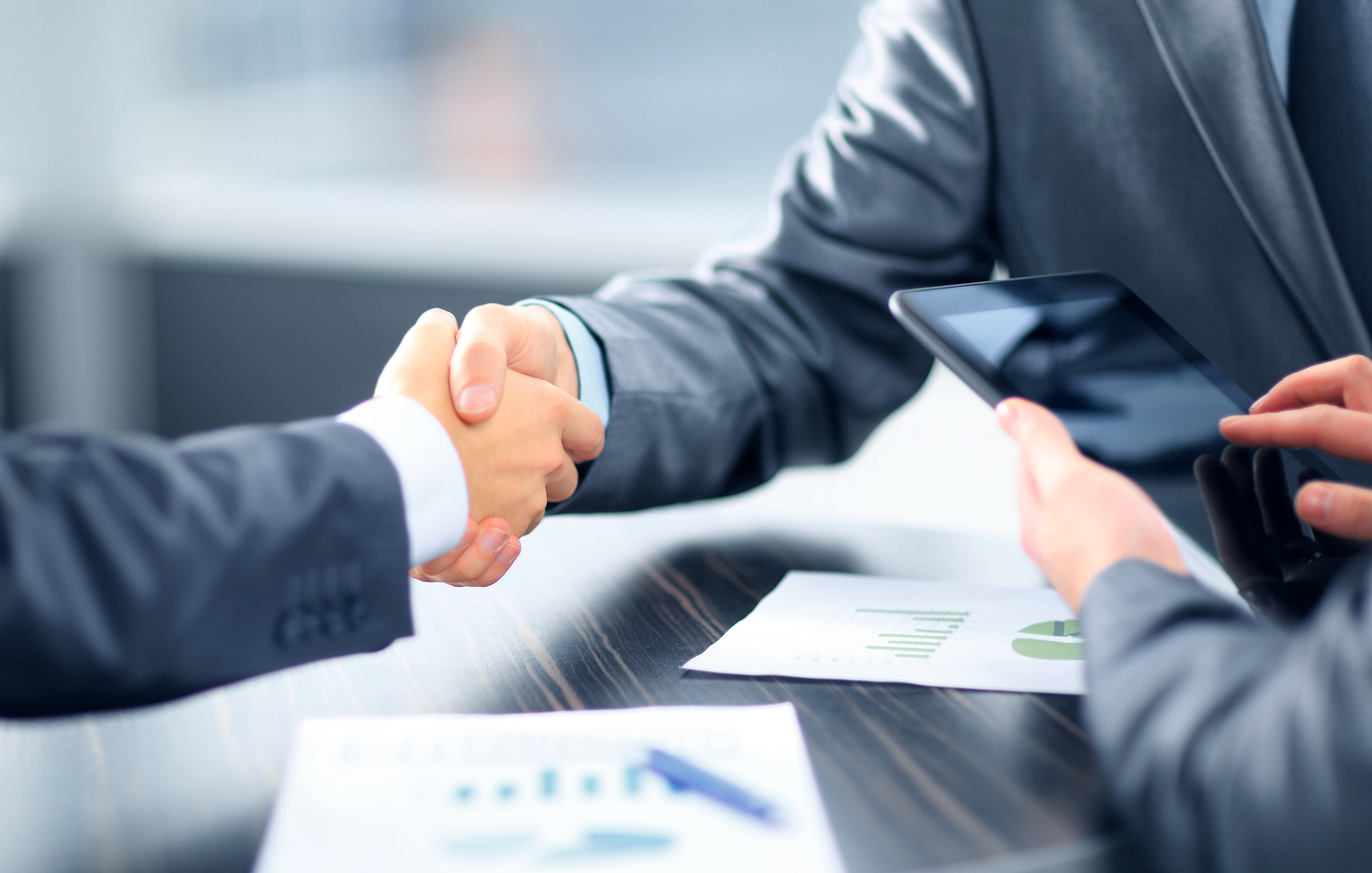 Business shaking hands in office