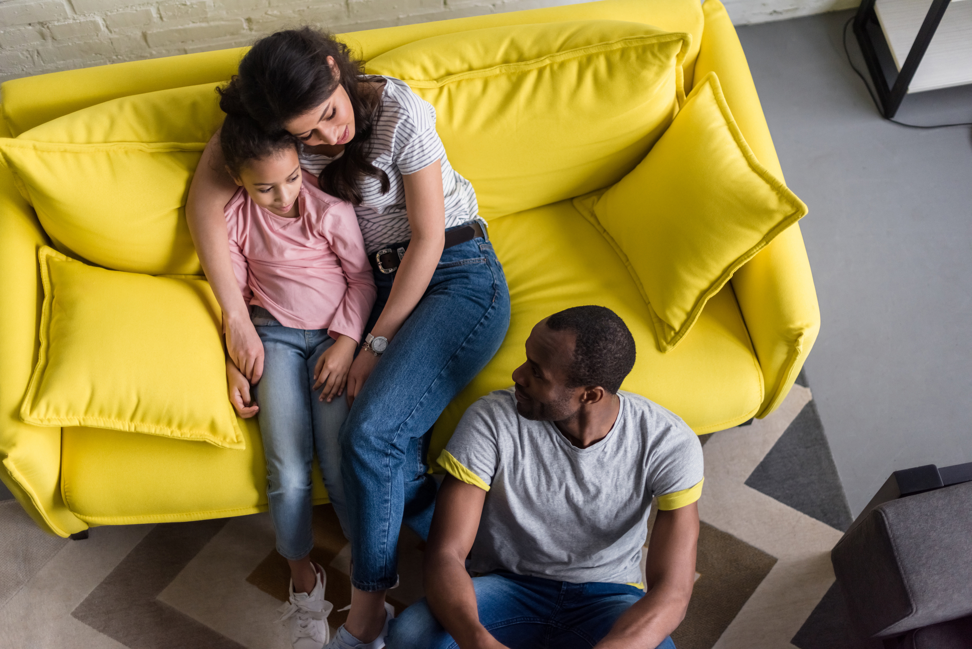 Top view of happy young family relaxing at living room